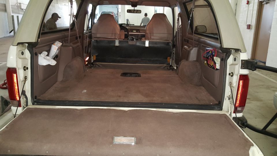 Tan interior of a 1992 Ford Bronco with the tailgate open, showing the cargo area and front seats