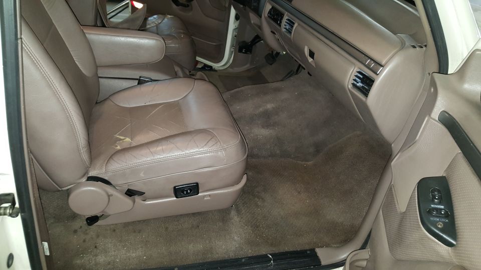 Tan leather front passenger seat and dashboard inside a white 1995 Ford Bronco, viewed through the open door