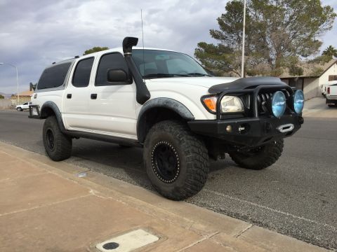 2001 Toyota Tacoma - A modified 2001 Toyota Tacoma pickup truck is parked on the side of the road.