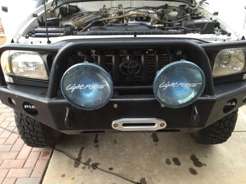 2001 Toyota Tacoma - Front view of a 2001 Toyota Tacoma showing its grille, headlights, and custom bumper with lights and winch.