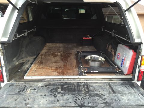 2001 Toyota Tacoma - The interior of a truck bed is shown, equipped with a platform, a dog bowl, and a first aid kit.