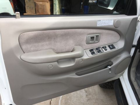 2001 Toyota Tacoma - Close-up of a vehicle's interior door panel, showing the armrest, door handle, and power window controls.