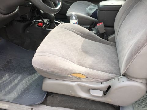 2001 Toyota Tacoma - Close-up of a worn car seat with a tear in the fabric.