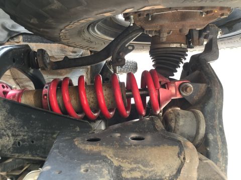 2001 Toyota Tacoma - Close-up view of a vehicle's front suspension system, highlighting a red coilover shock absorber.