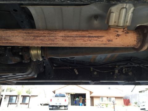 2001 Toyota Tacoma - The underside of a pickup truck is shown, with a white pickup truck parked in front of a garage in the background.