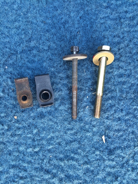 1981 Ford Bronco - Assorted automotive hardware, including U-nuts and bolts, laid out on a blue background.