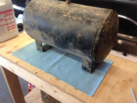 1979 Ford Bronco - A dirty black air tank rests on a workbench, ready for installation or repair.
