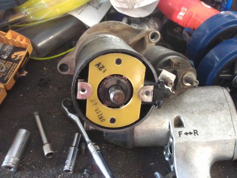 1994 Ford Bronco - A starter motor is shown with various sockets and a ratchet, suggesting repair work.