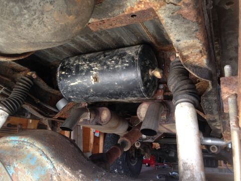 1979 Ford Bronco - Vehicle undercarriage with an air tank mounted above the exhaust system.