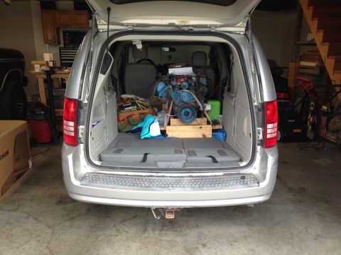 1979 Ford Bronco - Silver minivan with its trunk open, revealing a blue engine and various items inside.