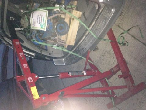 1979 Ford Bronco - Engine hoist secures a 1979 Ford Bronco engine for installation.