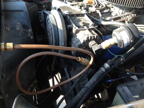 1979 Ford Bronco - Close-up of engine bay components, including a pressure gauge connected to AC lines.