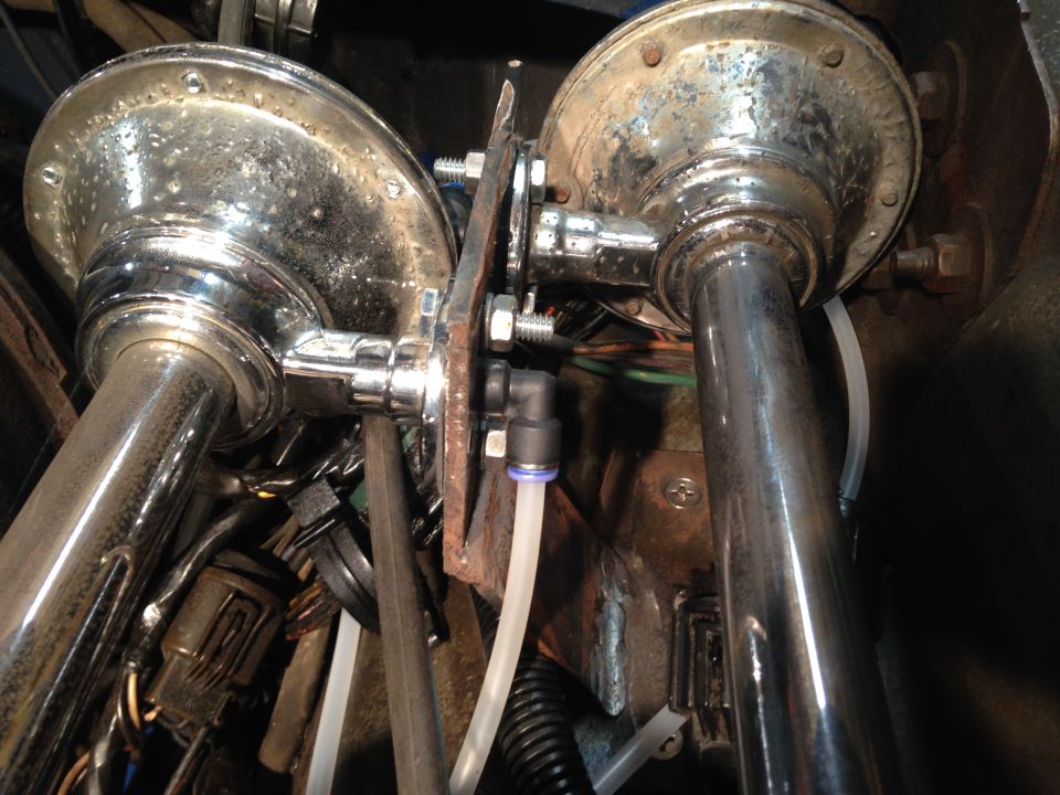 Close-up of chrome air horns mounted with tubing and wires