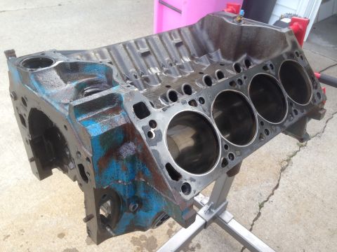 1979 Ford Bronco - Engine block on a stand, showing cylinder bores and some blue paint with rust.