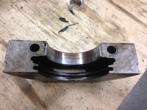 1979 Ford Bronco - Engine bearing cap showing wear on the bearing surface, with debris present.