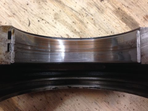 1979 Ford Bronco - Close-up of a worn engine bearing, indicating potential internal engine damage.