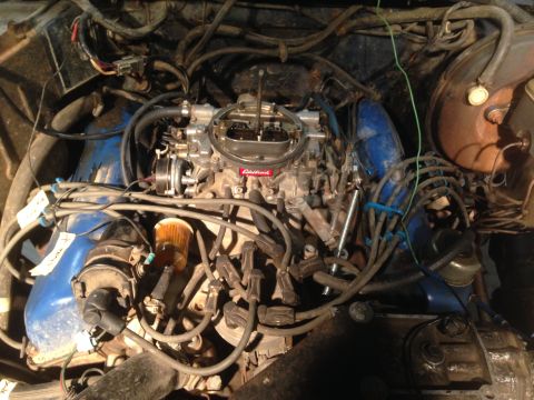 1979 Ford Bronco - Close-up view of a vehicle's engine bay, an Edelbrock carburetor and blue valve covers.
