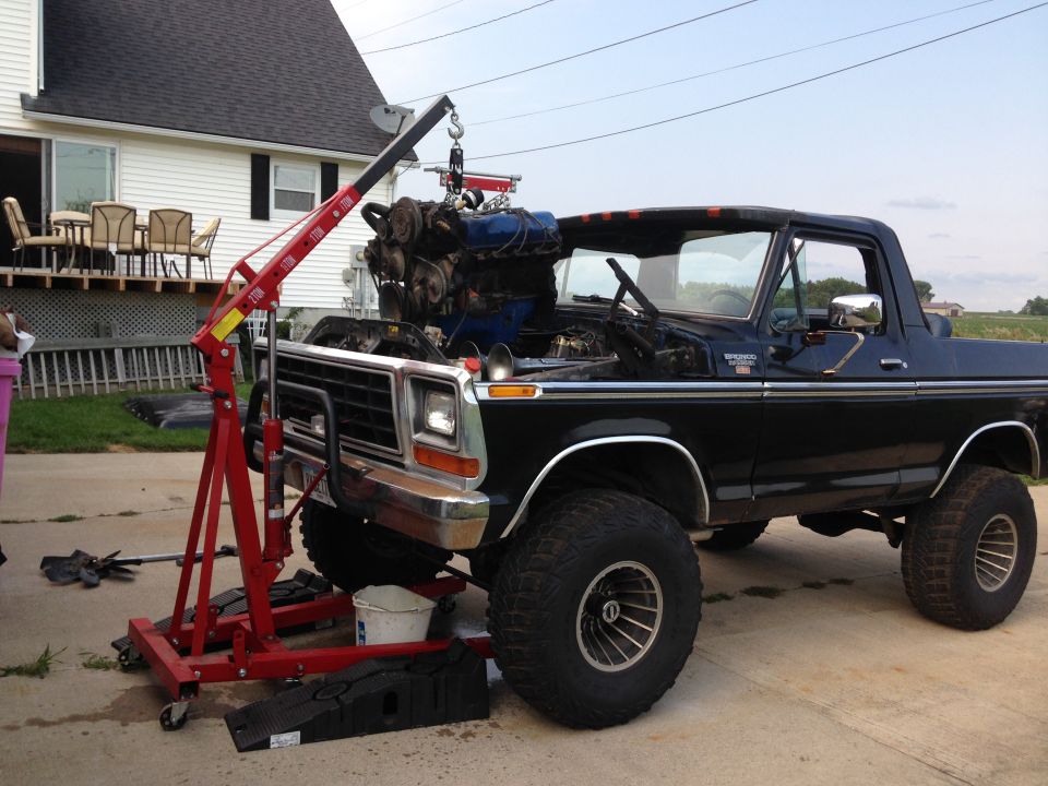 Black 1978 Ford Bronco with engine hoist lifting out the engine
