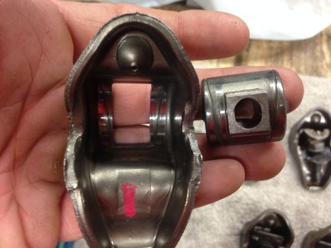 1979 Ford Bronco - A damaged engine rocker arm and pushrod are held for inspection, suggesting a need for engine rebuild.