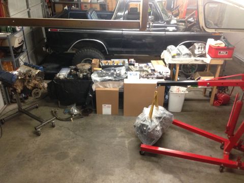 1979 Ford Bronco - A black 1978 Ford Bronco sits in a garage surrounded by engine components, ready for an overhaul.