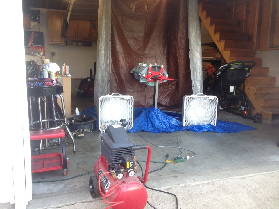 engine on a stand with fans and air compressor in a garage