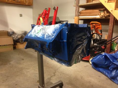 1979 Ford Bronco - Engine block covered in plastic sheeting sits on a stand in a garage.