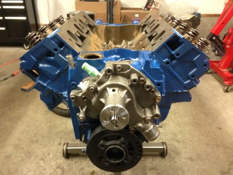 1979 Ford Bronco - A blue V8 engine, likely undergoing a rebuild, is displayed on a stand in a workshop setting.