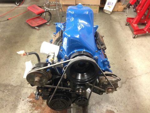 1979 Ford Bronco - A freshly painted engine assembly sits on a stand in a workshop, ready for installation.