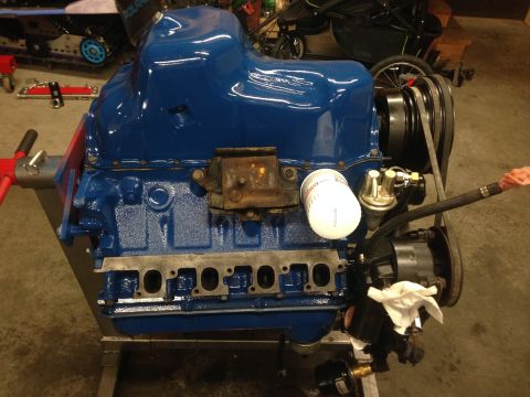 1979 Ford Bronco - V8 engine block with oil filter and accessories, mounted on an engine stand.
