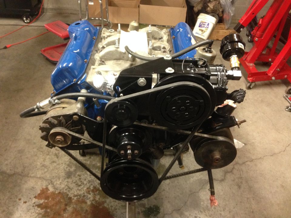 V8 engine assembly with blue valve covers, black accessories, and belts