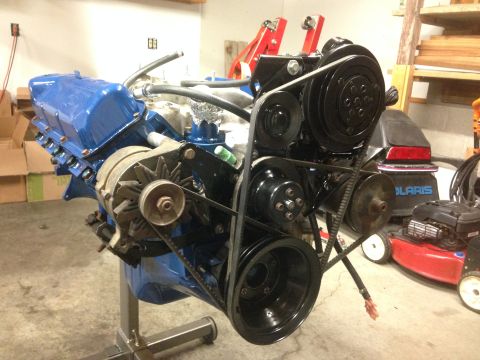 1979 Ford Bronco - Engine assembly on a stand, blue valve covers and black serpentine belt system.