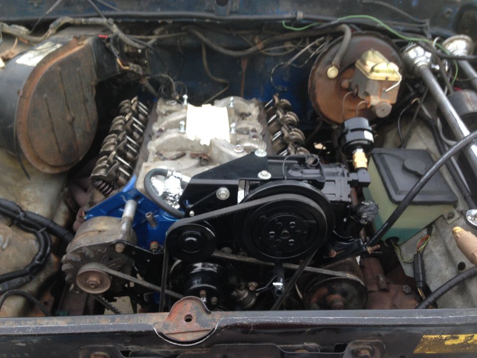 Engine bay with V8 engine, blue painted block, black accessories, and visible wiring