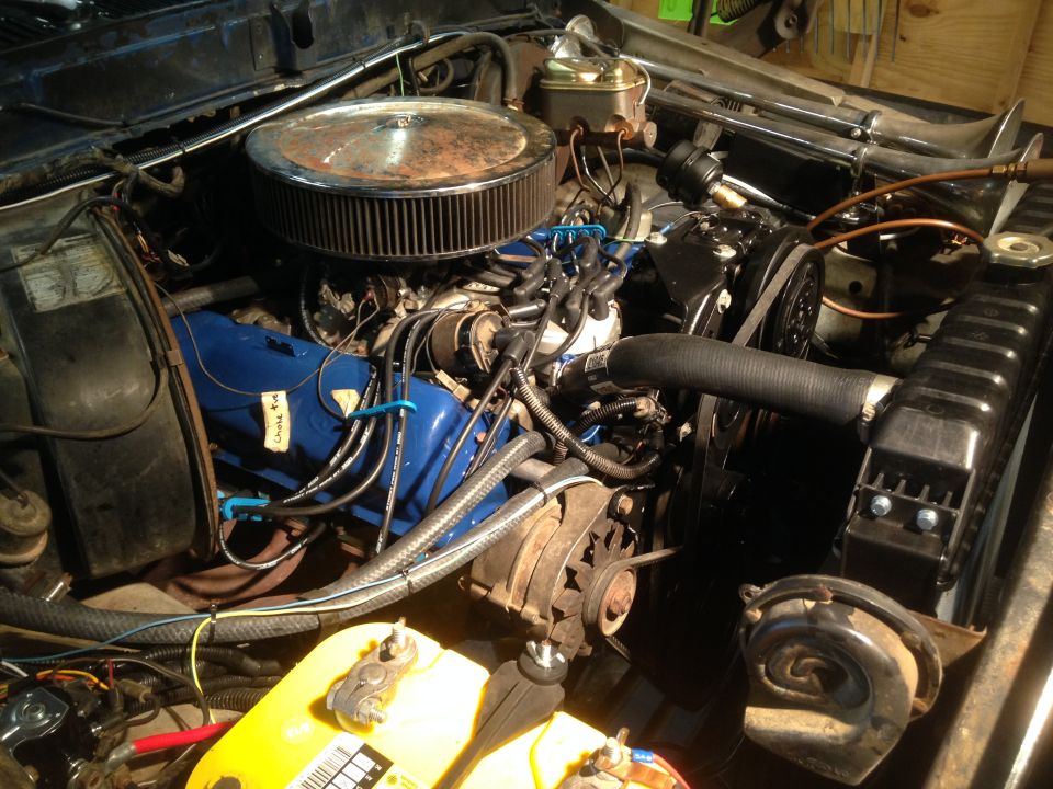 Engine bay with blue valve covers, chrome air cleaner, and yellow battery