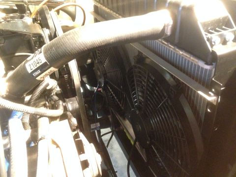 1979 Ford Bronco - The engine bay features a radiator with dual electric fans and a prominent coolant hose.