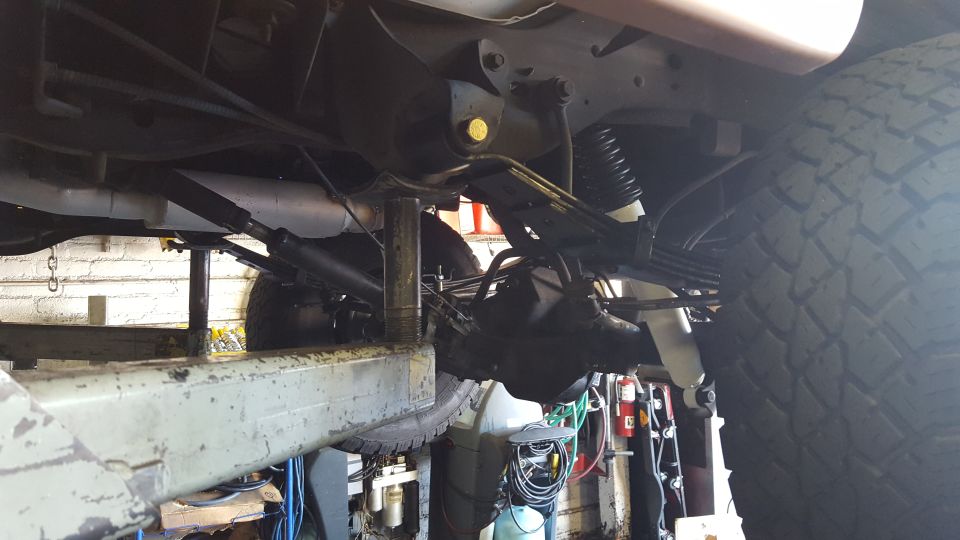 Underside view of a vehicle's rear axle, leaf springs, and shock absorbers