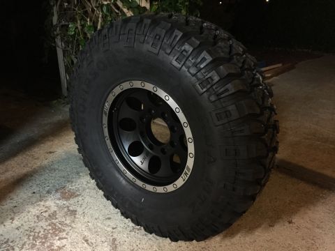 1989 Ford Bronco - Close-up of a black off-road wheel with MT tires, showing the "MUD-TERRAIN T/A" branding.