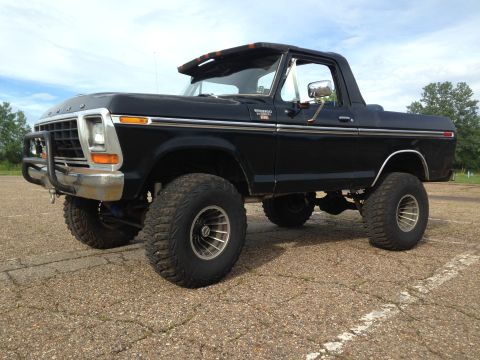 1979 Ford Bronco - This lifted 1979 Ford Bronco features a black exterior and prominent off-road tires.