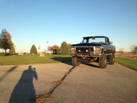 1979 Ford Bronco - A black 1979 Ford Bronco is parked outside on a sunny day with a clear blue sky.