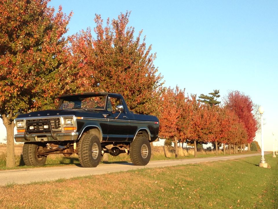 Black 1979 Ford Bronco with lifted suspension and off-road tires parked on a dirt road