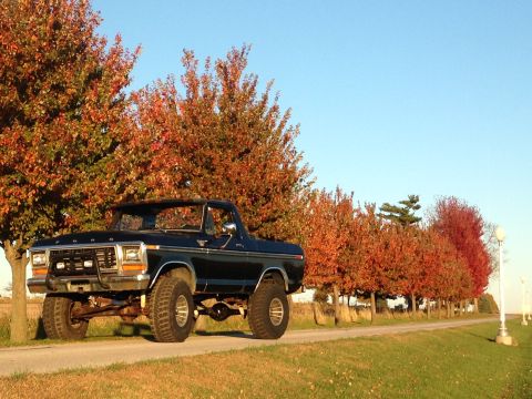 1979 Ford Bronco - A lifted 1978 Ford Bronco sits on a dirt road with fall foliage in the background.