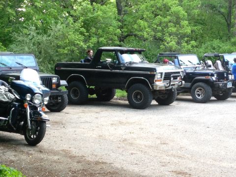 1979 Ford Bronco - A black Ford Bronco from the late 1970s is parked in a line with several Jeeps.