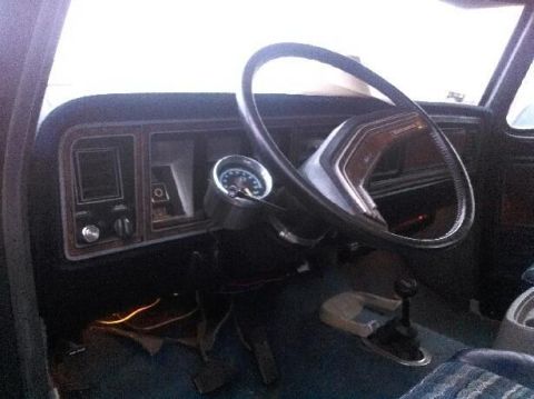 1979 Ford Bronco - The interior of a 1979 Ford Bronco shows its dashboard, steering wheel, and floor shifter.