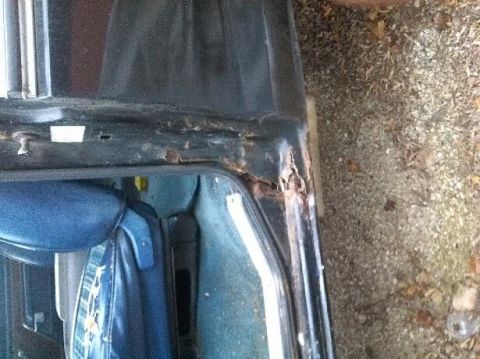 1979 Ford Bronco - Close-up of a vehicle's rusted door frame and interior, showing wear and tear.