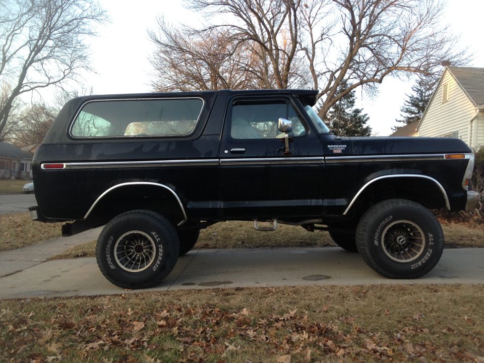 1979 Ford Bronco, side view. Black paint, chrome trim, aftermarket wheels