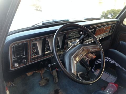 1979 Ford Bronco - The interior of a 1979 Ford Bronco shows wood grain accents on the dashboard and a black steering wheel.