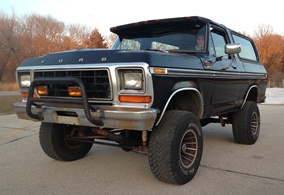 1979 Ford Bronco - A black 1978 Ford Bronco with a bull bar is parked outdoors, showing its front three-quarter view.