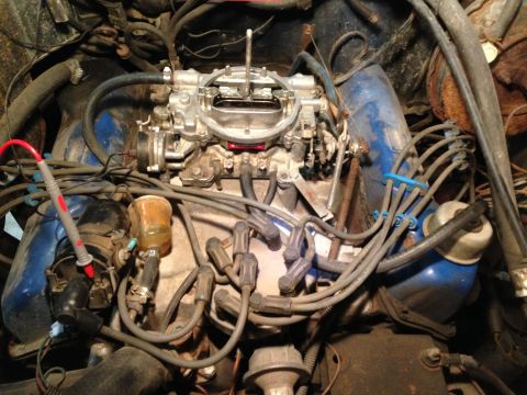 1979 Ford Bronco - Close-up view of a vehicle's engine bay, focusing on the carburetor and associated components.