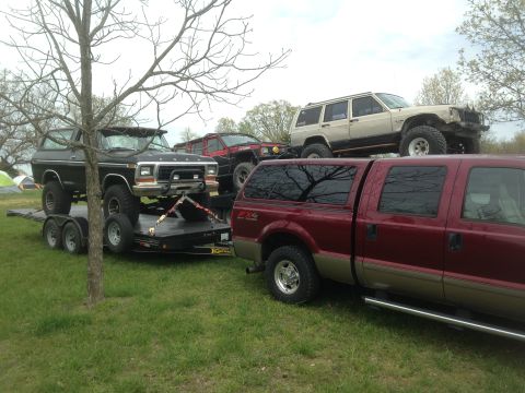 1979 Ford Bronco - A black 1978 Ford Bronco is transported on a trailer, accompanied by a red Ford Super Duty and other off-road vehicles.