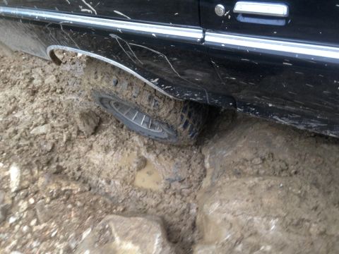 1979 Ford Bronco - A close-up view of a vehicle's tire and the bottom of its body panel.
