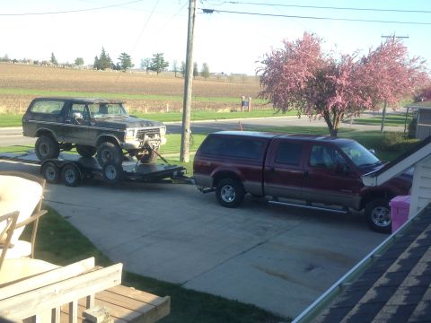 1979 Ford Bronco - Ford Bronco loaded onto a trailer, towed by a Ford F-250 Super Duty truck.